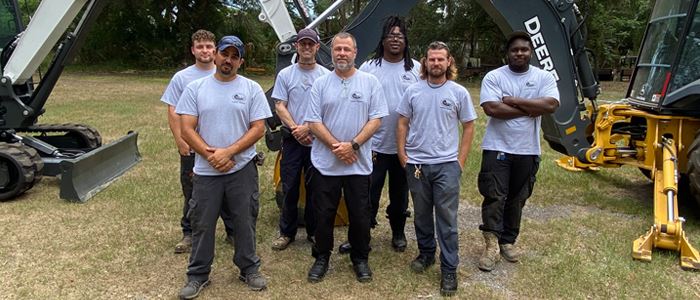 Water and Wastewater Division staff standing outside in front of heavy equipment
